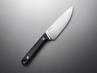 The Hells Canyon fixed blade knife on a steel surface with a black handle.