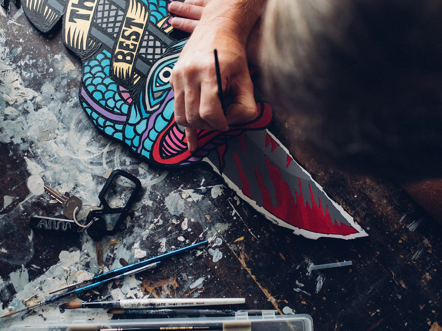UK artist Schoph Schofield painting on a wood panel.