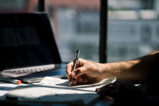 A person sketching with the Kent bolt-action pen.