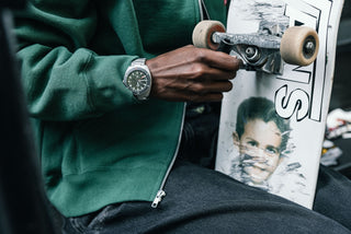 The James x Timex Automatic GMT watch on woman adjusting her skateboard.