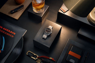 The James x Timex Automatic GMT watch on a platform surrounded by other gear.