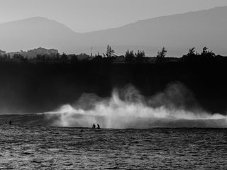 A group of surfers waiting out back on a big day at Waimea Bay, Oahu, Hawaii.