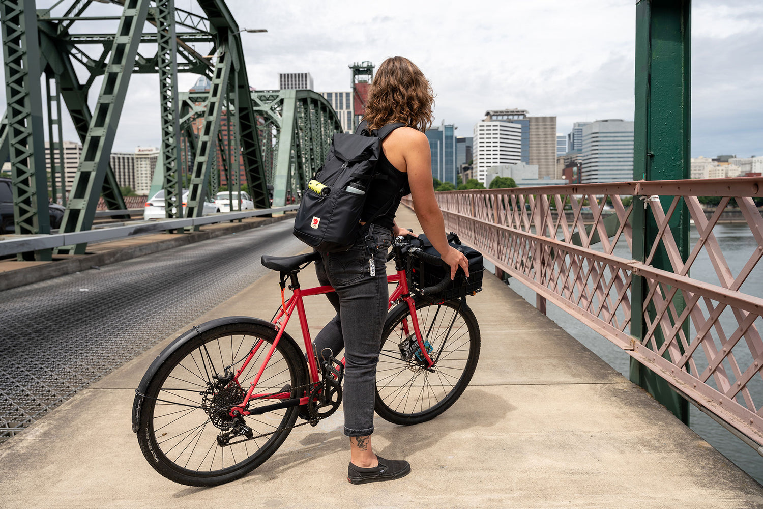 A woman riding her bike over a bridge into Portland, Oregon.