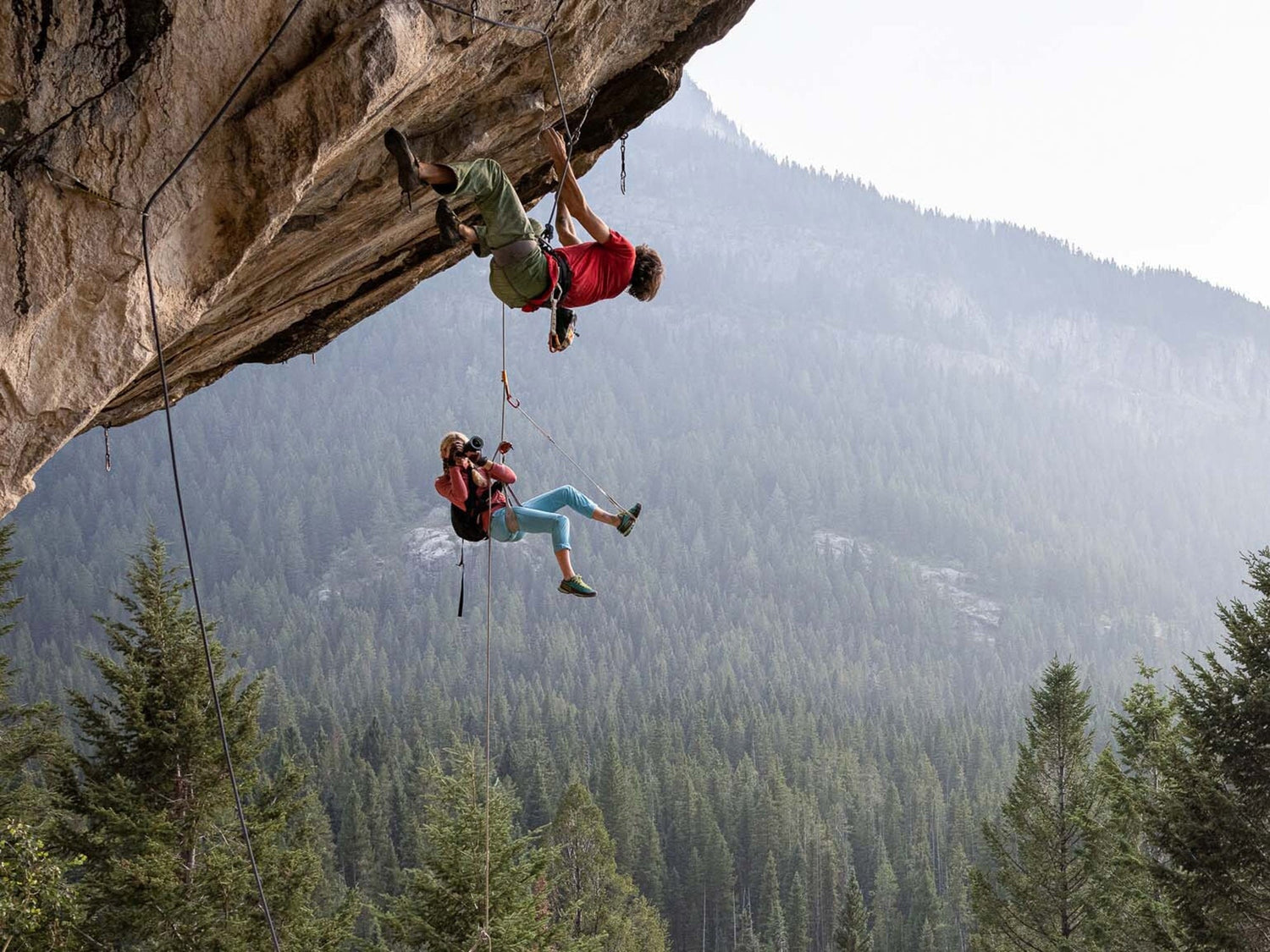 Professional rock climber and photographer Savannah Cummins taking photos of another climber.