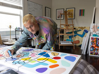 Artist and skateboarder Sebo Walker looking at the camera while painting.