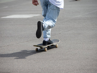 Artist and skateboarder Sebo Walker pushing his skateboard.