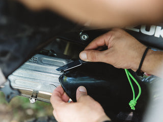 A motorcyclist using his Pike classic slip joint folding pocket knife to make a quick repair to his bike.