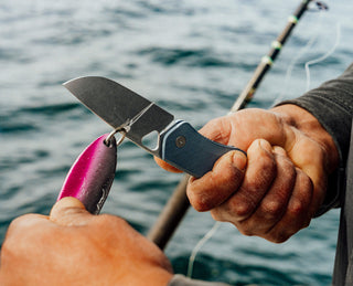 A fisherman cutting line on a lure with his Folsom Pro pocket knife.