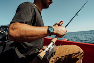 A fisherman wearing the James x Timex GMT Automatic titanium watch.