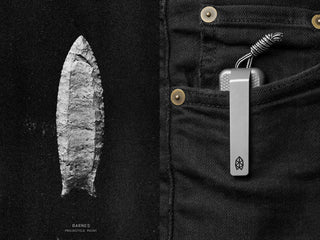 A Barnes arrow projectile point being shown next to a Barnes integral EDC titanium folding frame lock pocket knife in pocket.