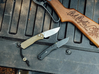 Two Carter EDC folding slide lock pocket knives on a truck bed in two sizes.