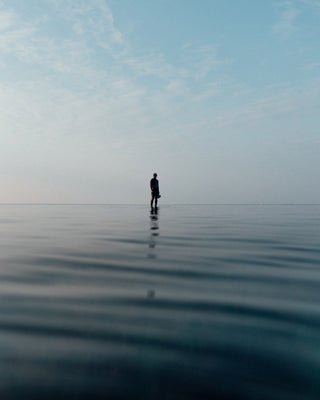 A photographer standing on a shallow sandbar in the North Sea.