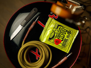The Wayland classic Barlow EDC folding slip joint black and stainless pocket knife on a bass drum with music equipment. 