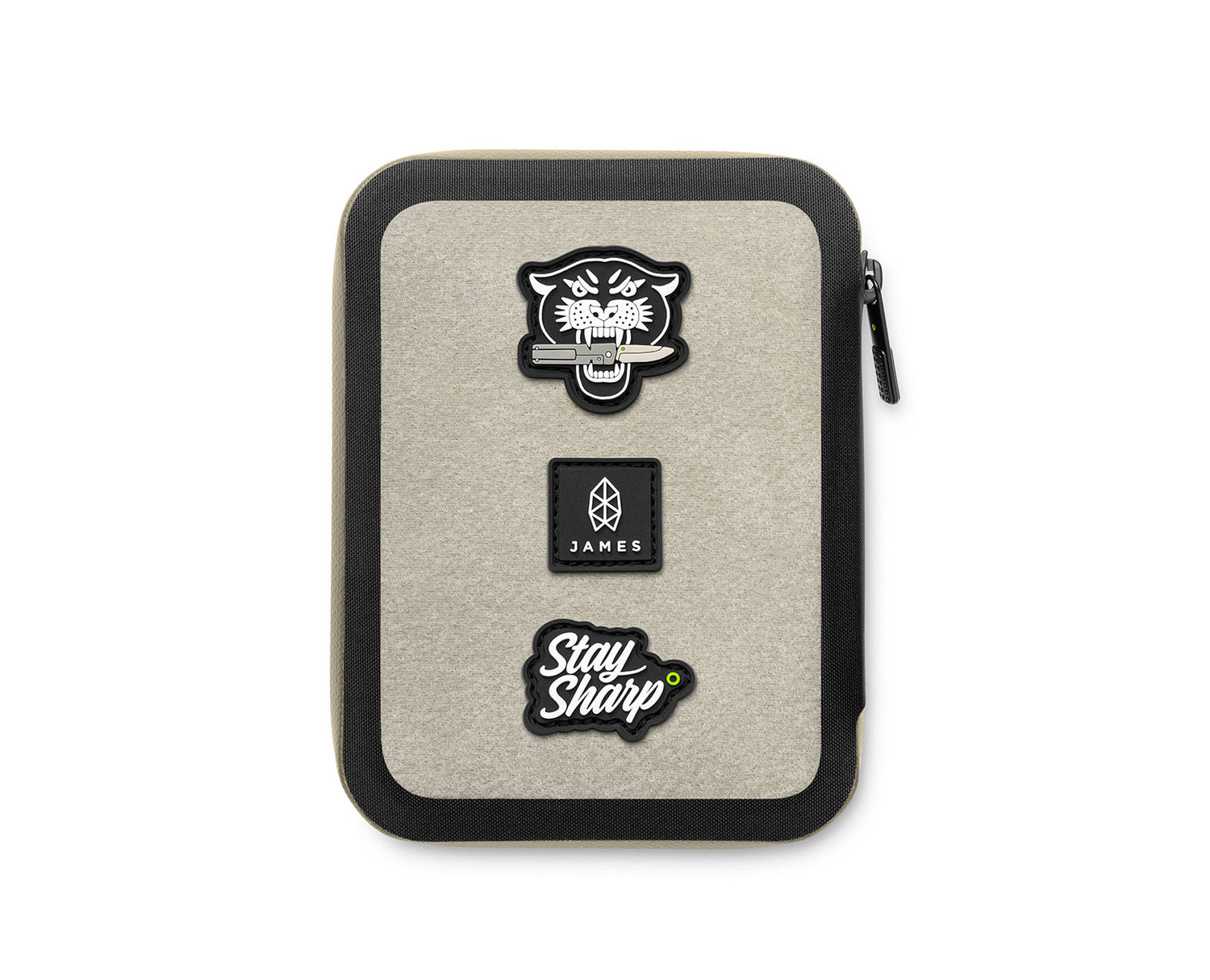 The backside of The Gatecliff travel case in coyote tan and black featuring The "Ranger Eye" patch set.