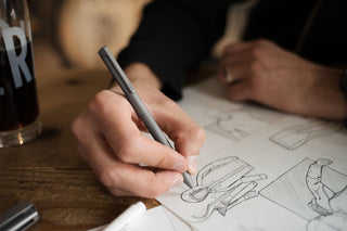 A person sketching with The Bolen titanium EDC twist pen.