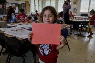An art student of Kahuku elementary school showing a boat painting.