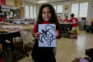 An art student of Kahuku elementary school showing her turtle painting.