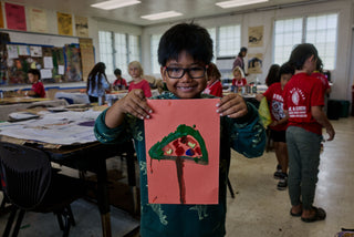 An art student of Kahuku elementary school showing his tree painting.