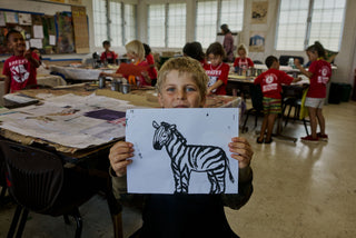 An art student of Kahuku elementary school showing his zebra painting.