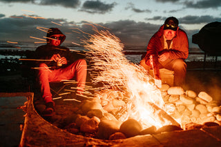 Two guys enjoying a beer around the campfire in Baja. 