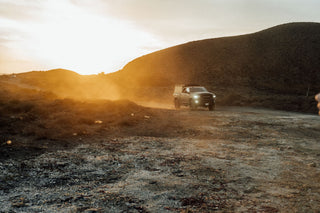 The sun setting over dusty dirt roads in Baja California.
