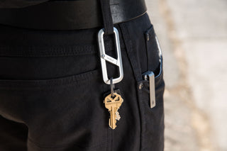 The Madison carabiner hanging from a belt loop.