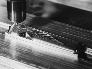 A CNC machine cutting out a knife's scale.