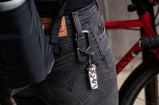 The Elko EDC keychain folding pocket knife with eco acetate scales hanging from a women's belt loop with keychain carabiner.