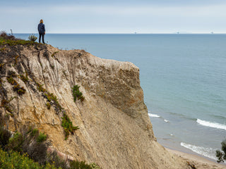 Professional surfer Connor Coffin checking the surf from a cliff in Santa Barbara, Californina.