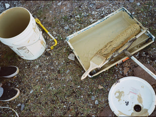 Artist Jess Mudgett's paint supplies on the ground.
