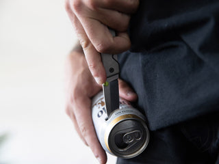 Artist Jess Mudgett opening a beer with his Chapter EDC folding pocket knife.