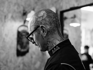 Professional barber Paul Hewitt looking over his client.