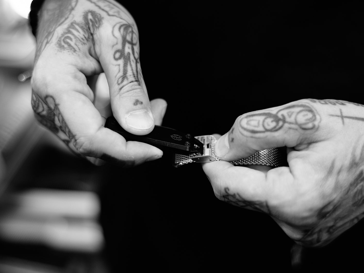 Professional barber Paul Hewitt adjusting the strap on his watch with the pry bar of his Elko keychain knife.