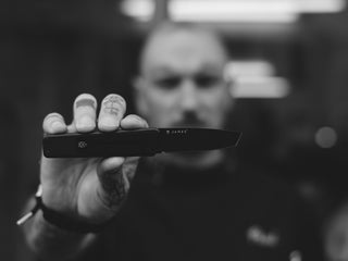 Professional barber Paul Hewitt holding up his Chapter EDC folding frame lock pocket knife.