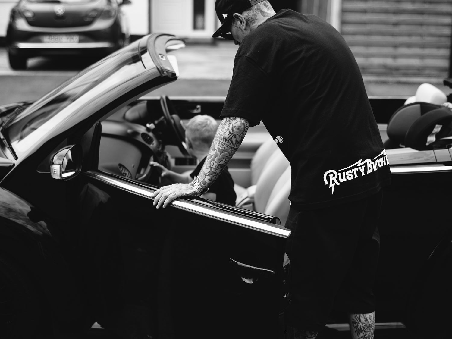 Professional barber Paul Hewitt getting into his convertible with his son.