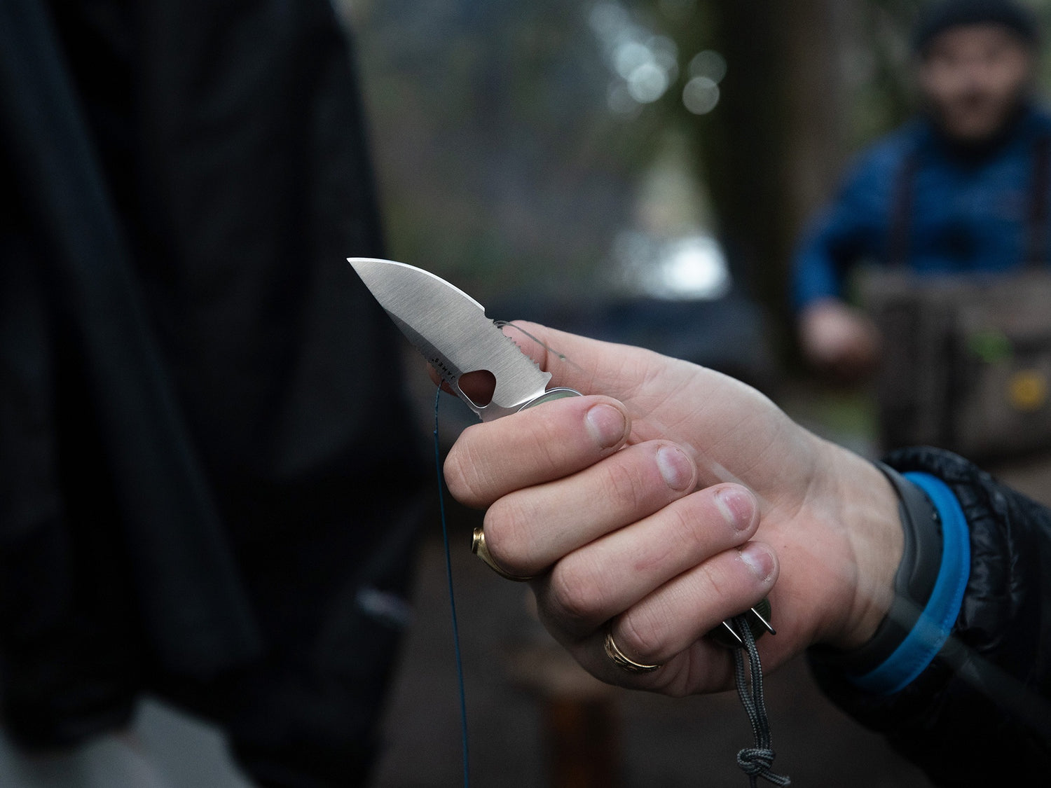 A fisherman using the serrated blade of there Redstone folding slide lock pocket knife.