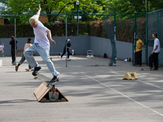 Artist and skateboarder Sebo Walker doing a crook grind on a rail.