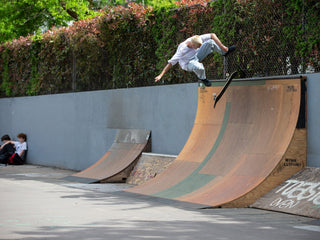 Artist and skateboarder Sebo Walker kick flipping on a quarter pipe.