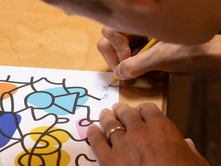 Artist and skateboarder Sebo Walker signing an art print.